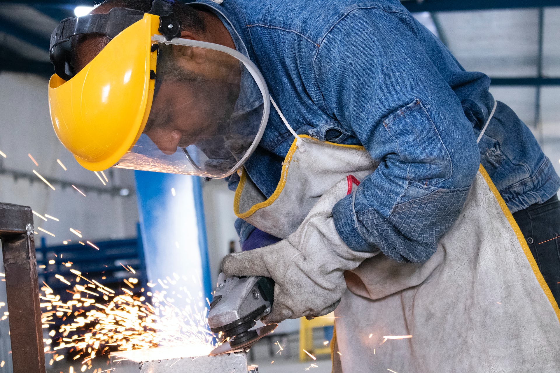 Teknologi pengelasan industri digunakan oleh pekerja untuk menyambungkan struktur logam dengan perlindungan helm dan sarung tangan.